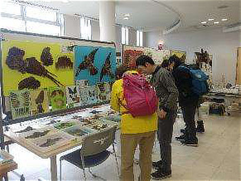 管理事務所ホールでの展示物を興味深くみる参加者たち